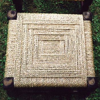 This photograph shows a seagrass seat woven by Sue on a small square stool.